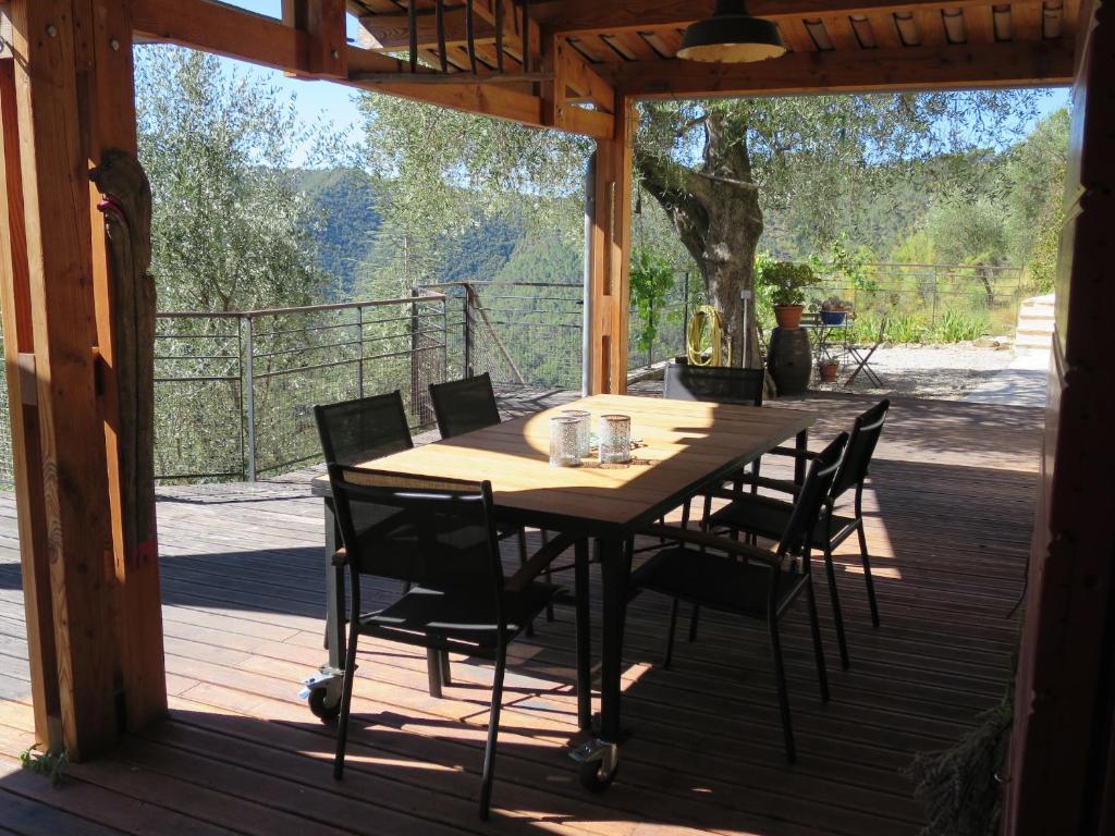 une table et des chaises en bois sur une terrasse dans l'établissement Les Figaires, à LʼEscarène