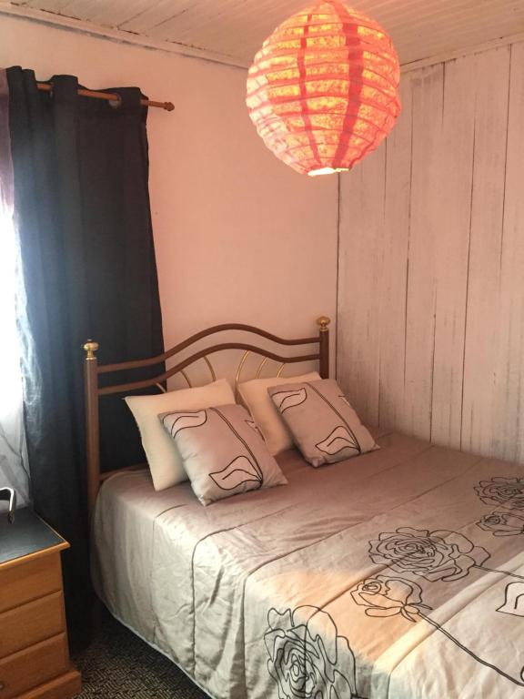 a bedroom with a bed and a chandelier at Casa Urgueira in Pendilhe