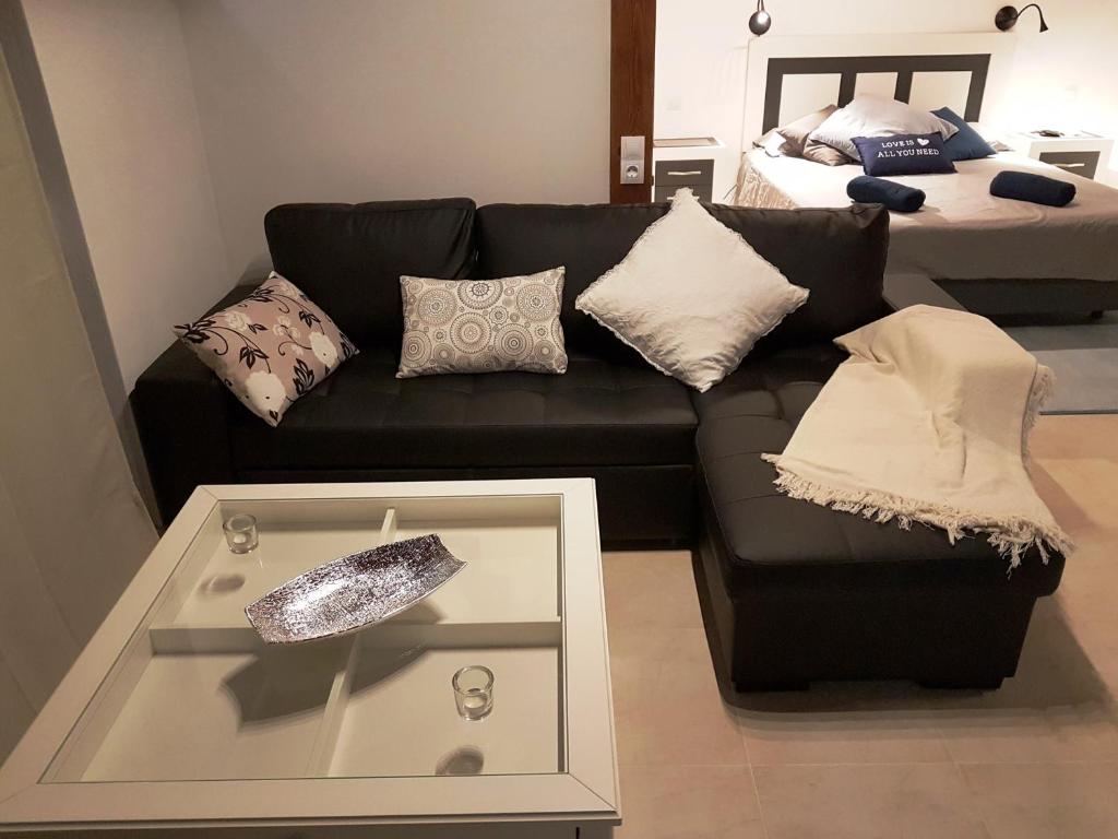 a living room with a black couch and a bed at Las Arecas Loft in Playa Blanca