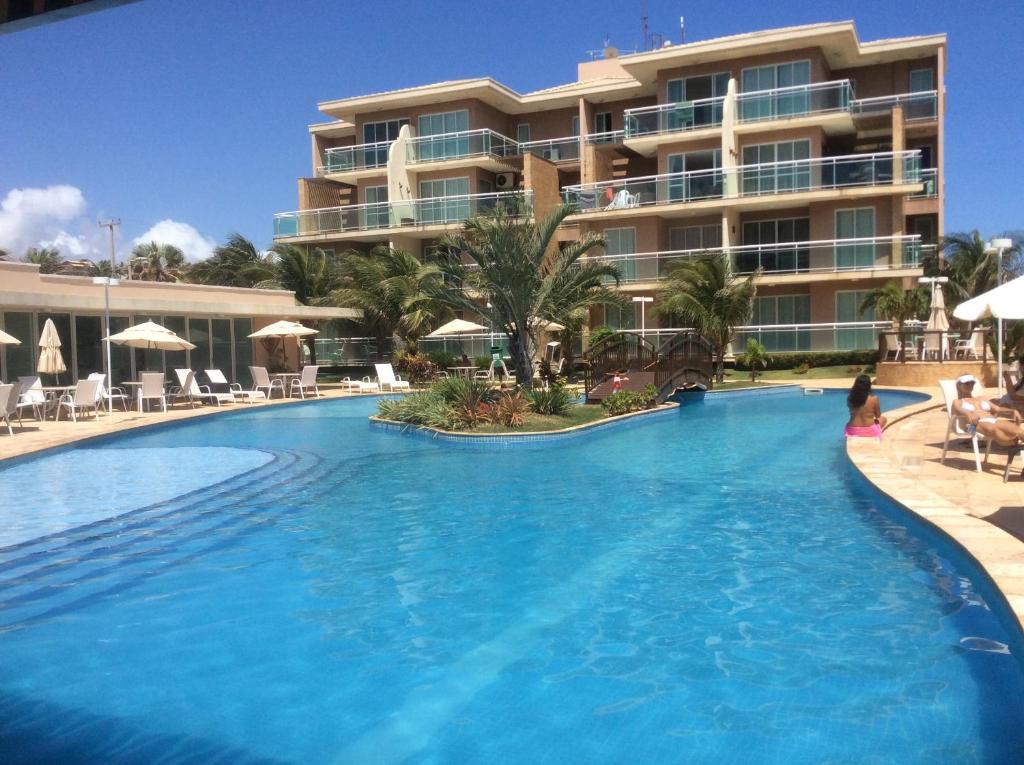 a large swimming pool in front of a hotel at Condomínio Palm Beach in Aquiraz