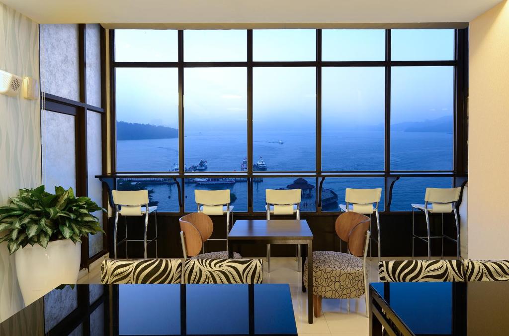a room with a table and chairs and a large window at Hu Yue Lakeview Hotel in Yuchi