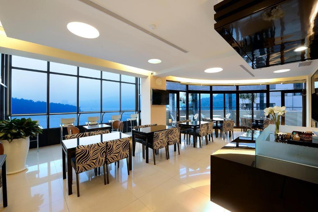 - une salle à manger avec des tables, des chaises et des fenêtres dans l'établissement Hu Yue Lakeview Hotel, à Yuchi