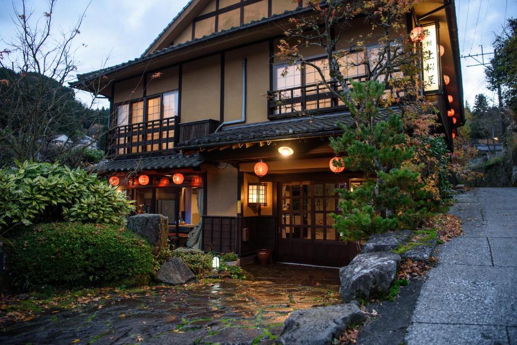 uma casa japonesa com lanternas na frente. em Yunohira Kamiyanagiya em Yufu