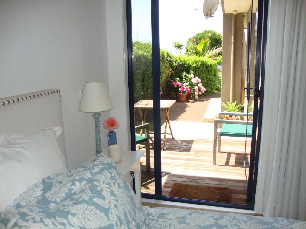 a bedroom with a bed and a view of a patio at Beachfront Bliss in Ohope Beach