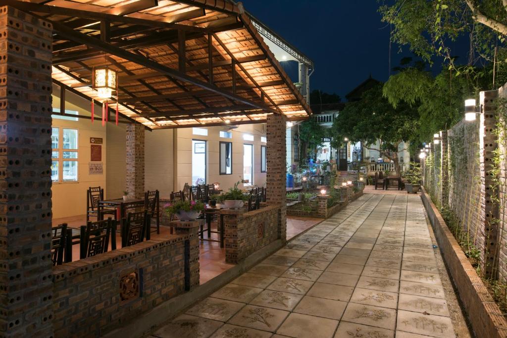 an outdoor patio with awning and tables and chairs at Tam Coc Craft Homestay in Ninh Binh