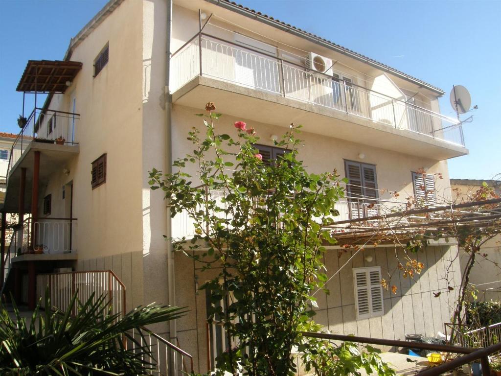 - un bâtiment blanc avec un balcon et un arbre dans l'établissement Apartments Pasko, à Primošten