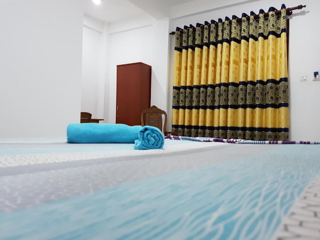 a swimming pool in a room with a blue and yellow curtain at Wick's Apartment in Hikkaduwa