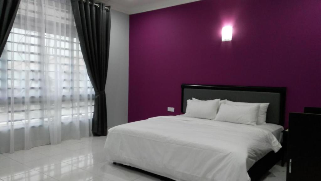 a bedroom with a purple wall and a bed at ARA Muslim House @ Mutiara Heights Johor Bahru in Johor Bahru