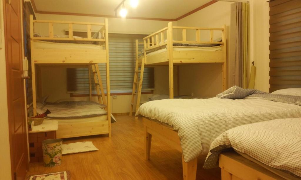 1 Schlafzimmer mit 2 Etagenbetten und einem Schreibtisch in der Unterkunft Geoje Ton Ton Guesthouse in Geoje