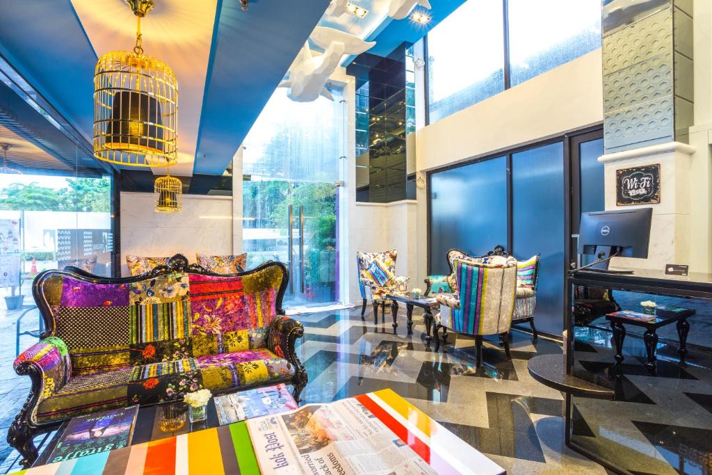 a lobby with colorful furniture and a table and chairs at Hotel Clover Asoke - SHA Extra Plus in Bangkok