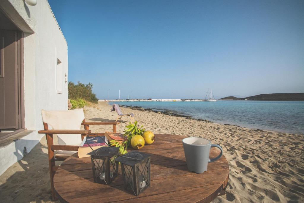 a table on a beach with a chair and some fruit at Donusa Beach House - Etheras properties in Diakofti