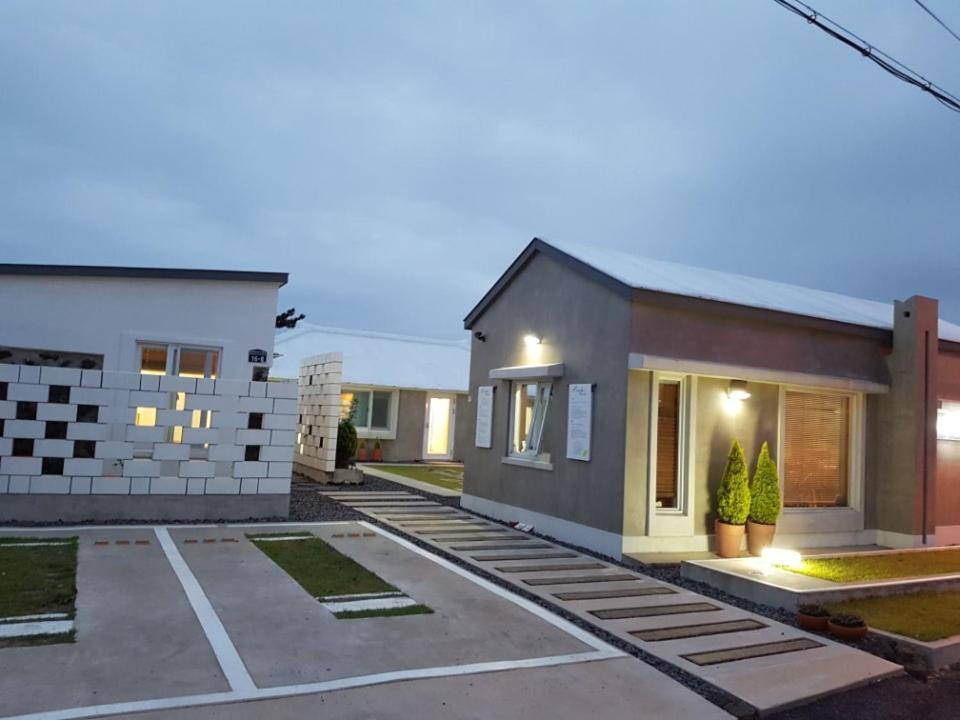 a house with a driveway in front of it at Bookmark Guesthouse in Seogwipo