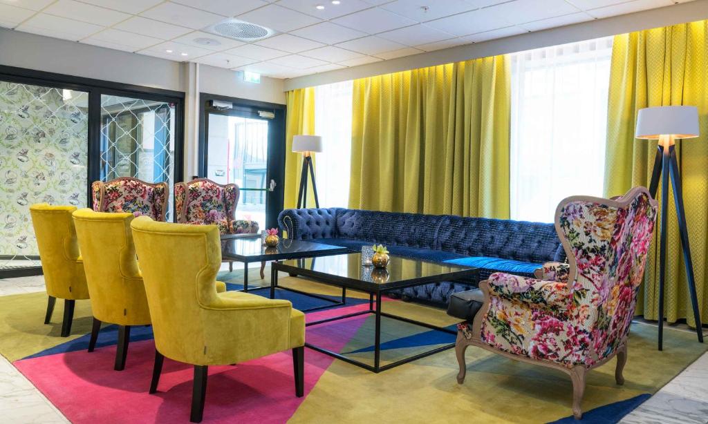 ein Wohnzimmer mit einem Sofa, einem Tisch und Stühlen in der Unterkunft Thon Hotel Arendal in Arendal