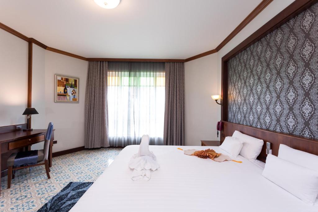 Postel nebo postele na pokoji v ubytování Erawan Hotel