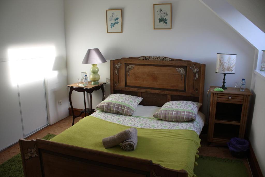 una camera da letto con un grande letto con una coperta verde di Yec'Hed Mat a Saint-Nicolas-du-Pélem
