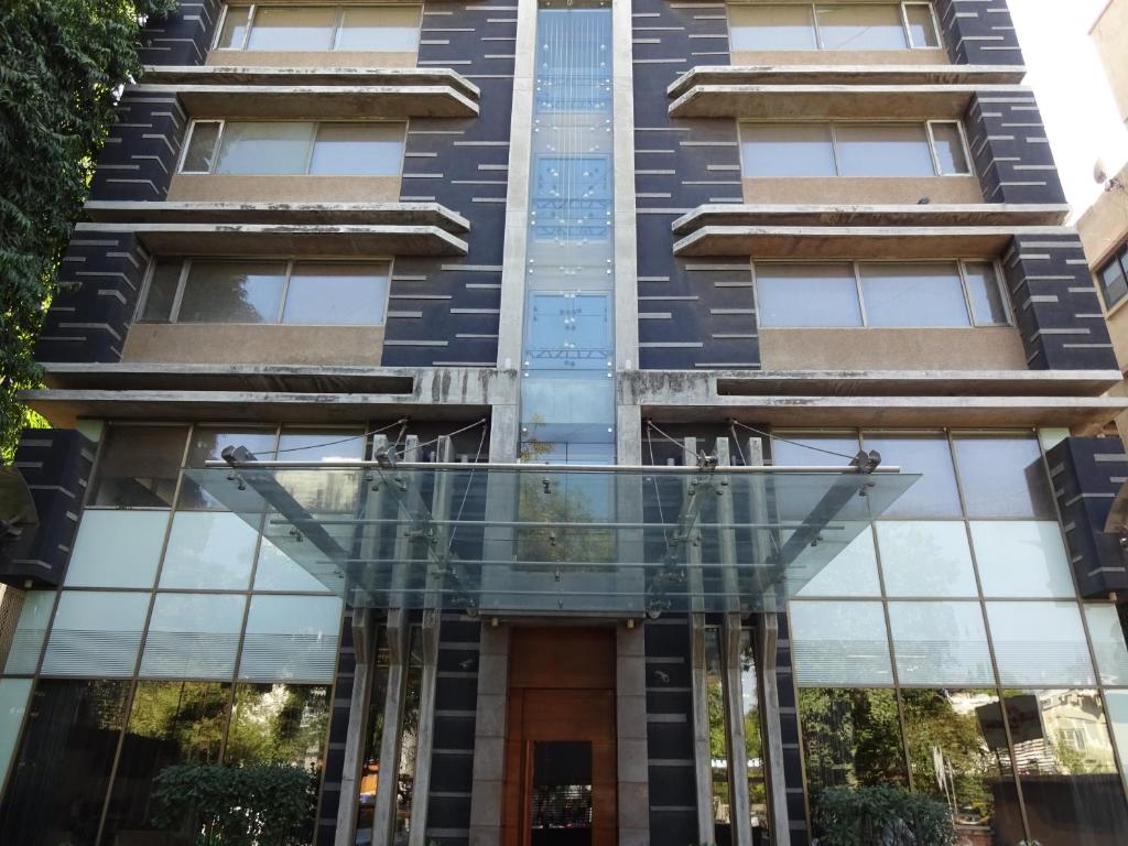 a building with a glass door in front of it at Hotel Cosmopolitan in Ahmedabad