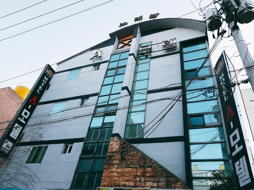 un edificio con ventanas de cristal y una señal en él en Gumi A Motel, en Gumi