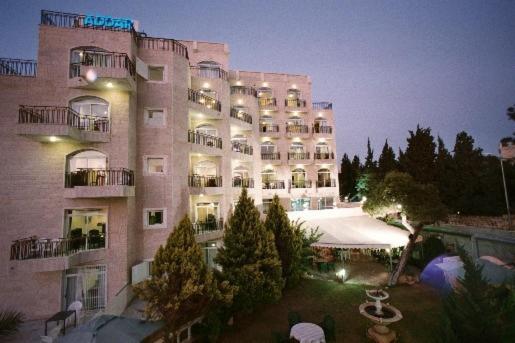 a large building with a courtyard in front of it at Addar Hotel in Jerusalem