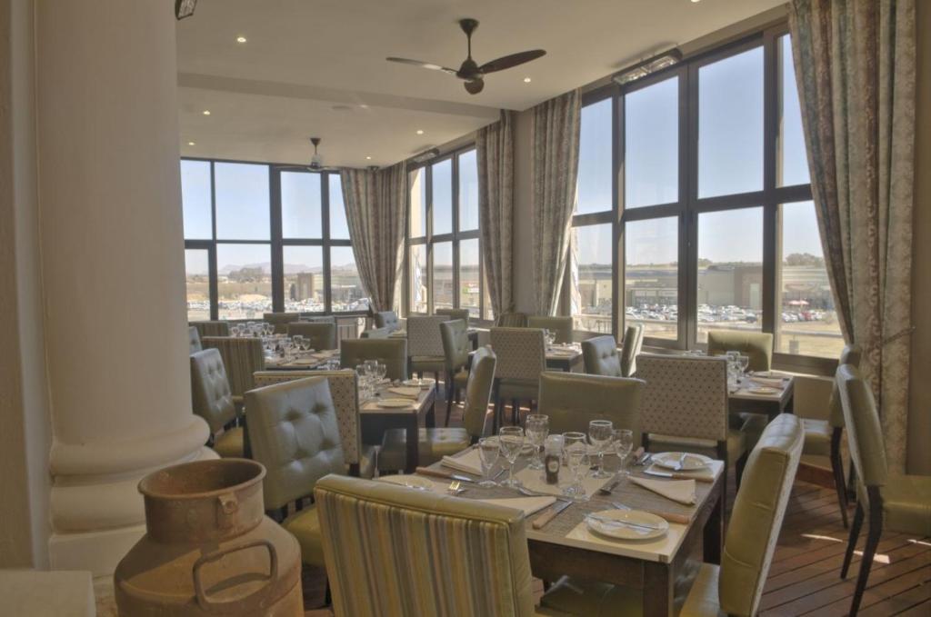 伯利恆的住宿－邊疆皮爾蒙特米特庫爾特酒店，伯利恆，餐厅设有桌椅和大窗户。