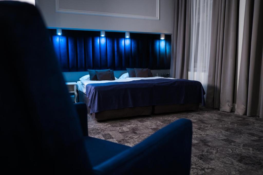 Habitación de hotel con 2 camas y luces azules en City Boutique Hotel en Zielona Góra