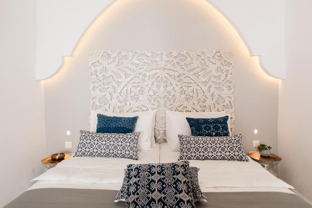 a bedroom with a white bed with blue pillows at Jasmine Holiday Villa in Episkopí- Rethimno