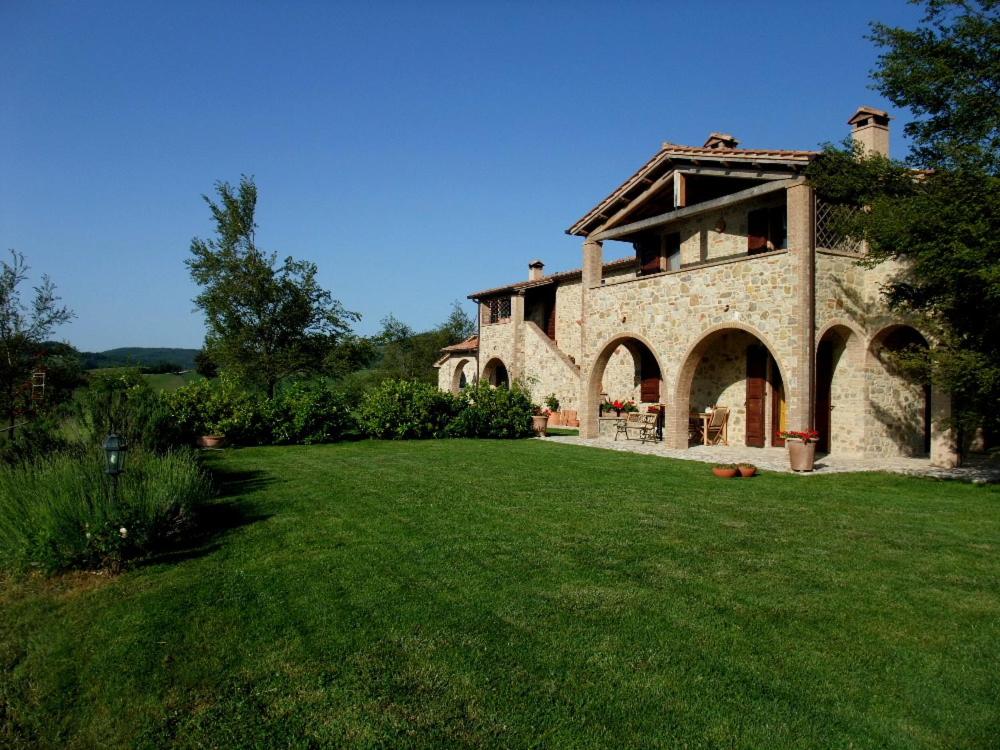 une grande maison en pierre avec une pelouse verte dans l'établissement Agriturismo Pian di Frattina, à Fabro