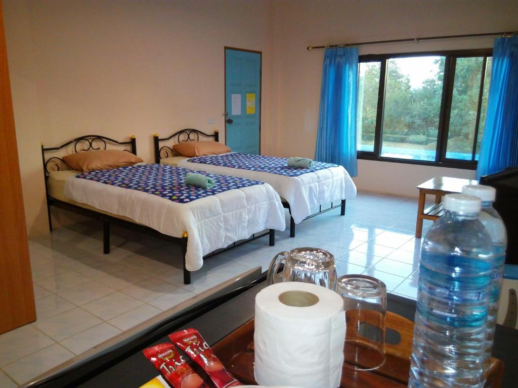 a bathroom with two beds and a sink with a sink at Peace Pool Resort in Khun Han