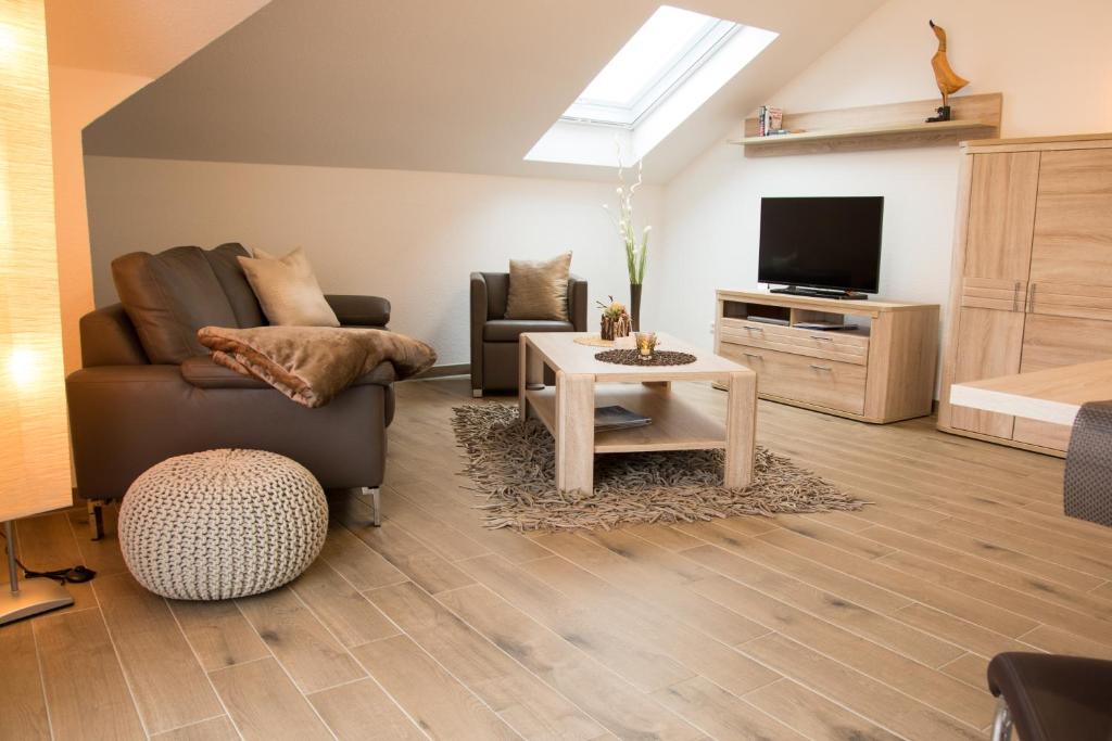 a living room with a couch and a tv at Appartementhaus Elm Immobilien in Königslutter am Elm