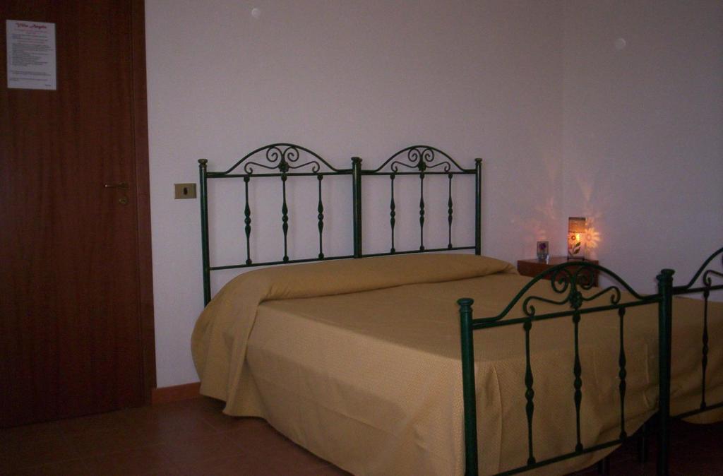シャッカにあるCasa vacanze VILLA ANGELA in Sicilia con pool house country per 16 guestのベッドルーム1室(金属製ヘッドボード付きのベッド1台付)