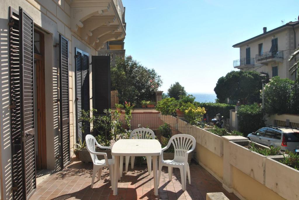 patio con mesa y sillas en el balcón en La Perla, en Castiglioncello