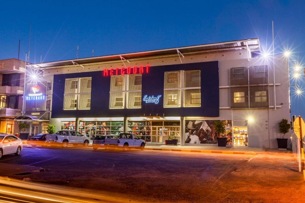 a building with cars parked in front of it at night at Peermont Metcourt Hotel in Francistown