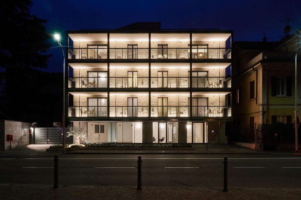 a lit up apartment building at night at La Perla by Sedar in Como