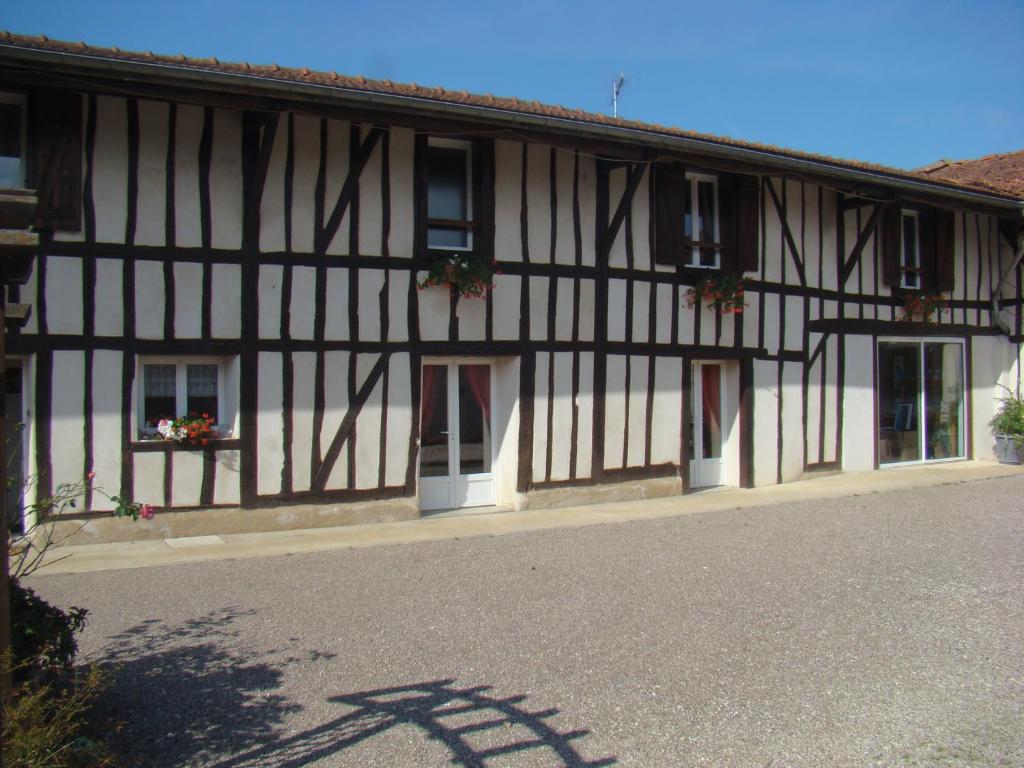 um edifício a preto e branco com portas e janelas brancas em Gite La Sente des Vignes em Hauteville