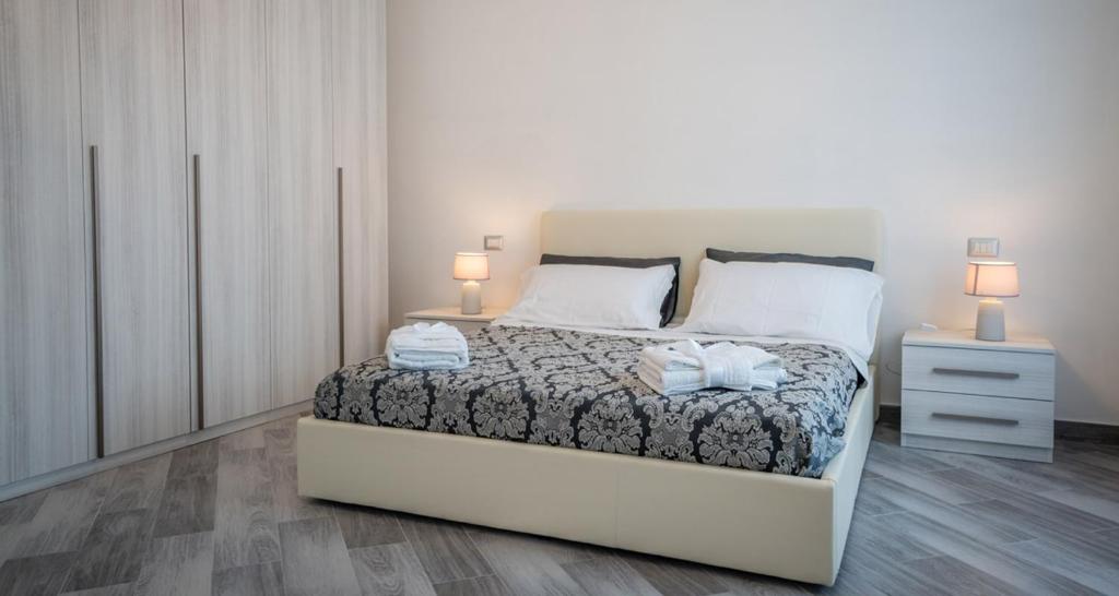 アニョーネにあるCasa Vacanza Dianaのベッドルーム1室(ベッド1台、ナイトスタンド2台、ランプ2つ付)