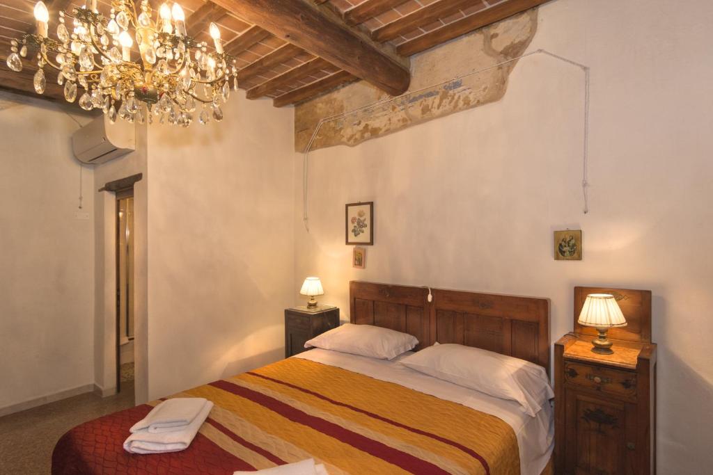 een slaapkamer met een bed en een kroonluchter bij B&B due Borghi 3 in Pisa