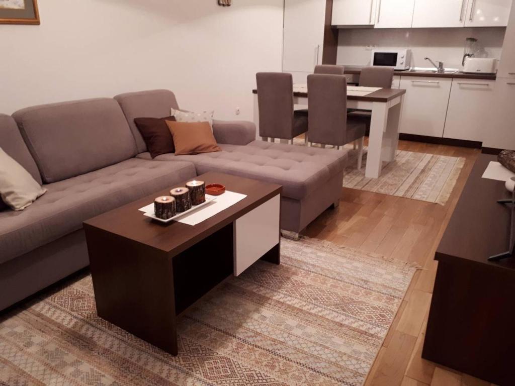 a living room with a couch and a table at Apartman SL Bjelasnica in Sarajevo