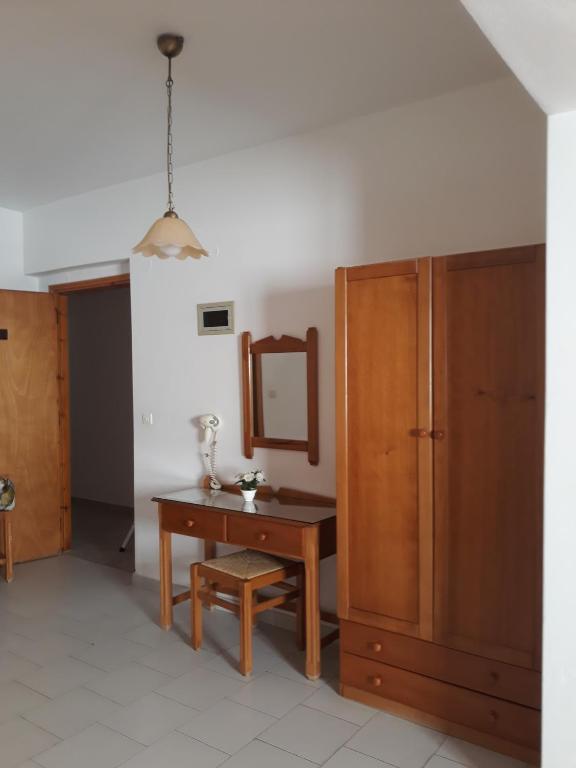 a room with a desk and a mirror and a cabinet at Amaryllis Hotel in Karpathos