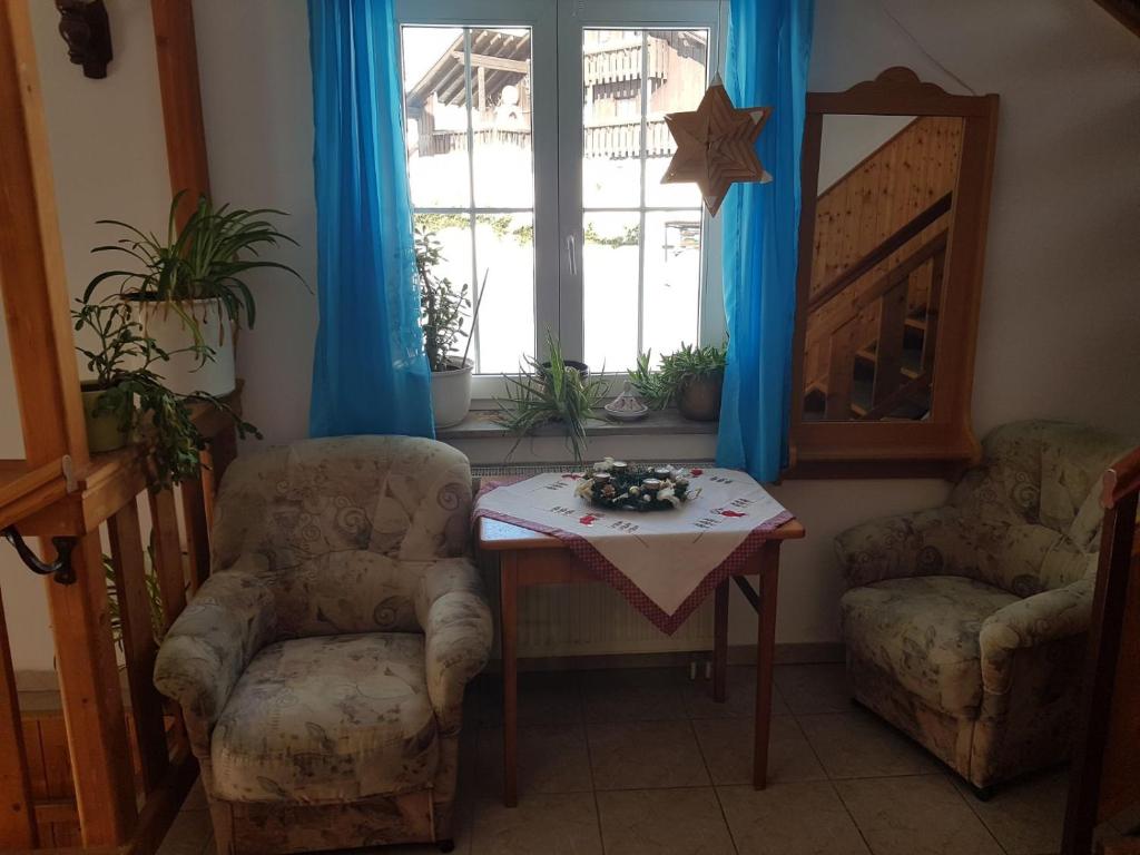 a room with two chairs and a table and a window at Ubytování Maxa in Špičák
