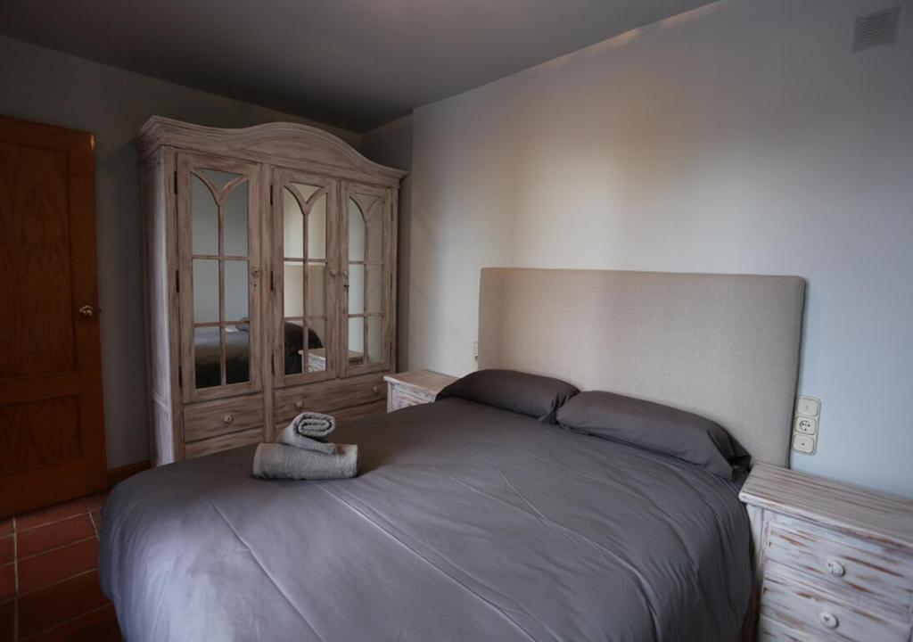 sypialnia z dużym łóżkiem i drewnianą szafką w obiekcie Chalet Adosado zona med/baja w mieście Sierra Nevada