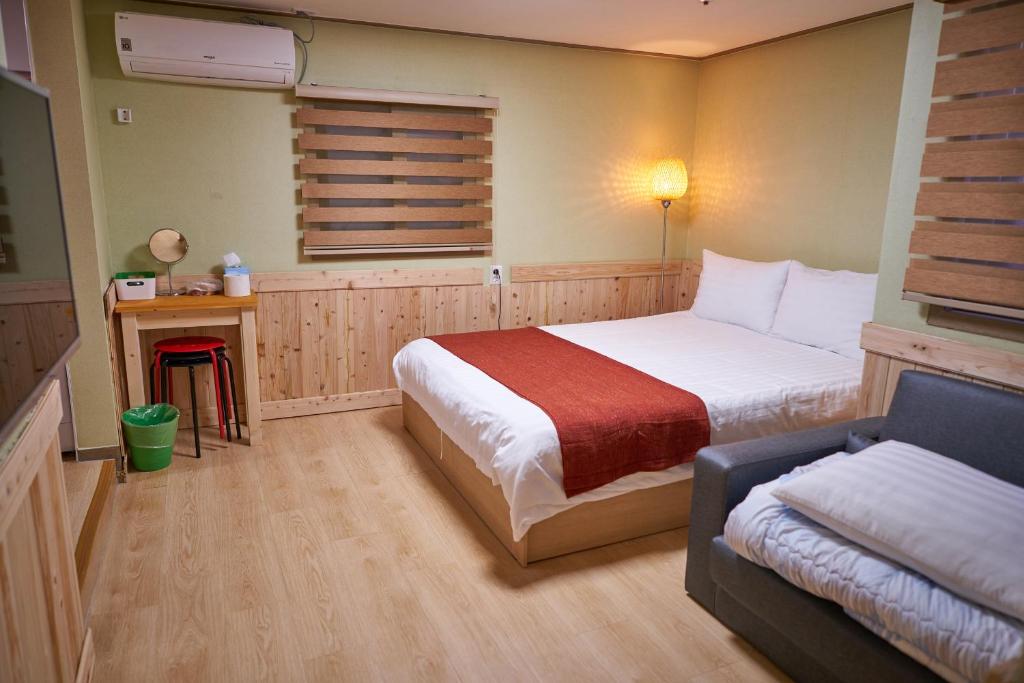 ein Schlafzimmer mit einem Bett und einem Sofa darin in der Unterkunft Seoul Station R Guesthouse in Seoul