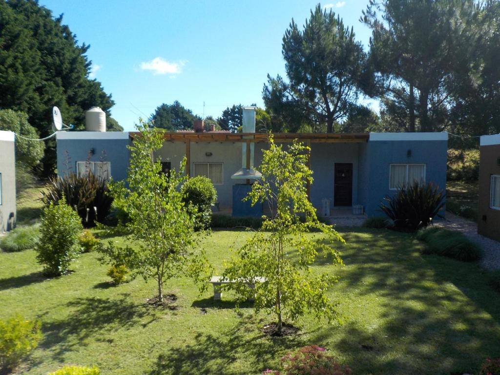 a house with trees in front of a yard at Firenze Cabañas - Playa Chapadmalal in Chapadmalal