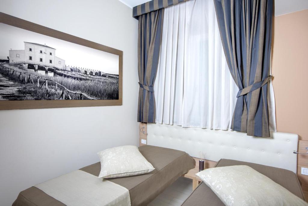 a living room with a couch and a window at Hotel C'era Una Volta in Castiglione della Pescaia