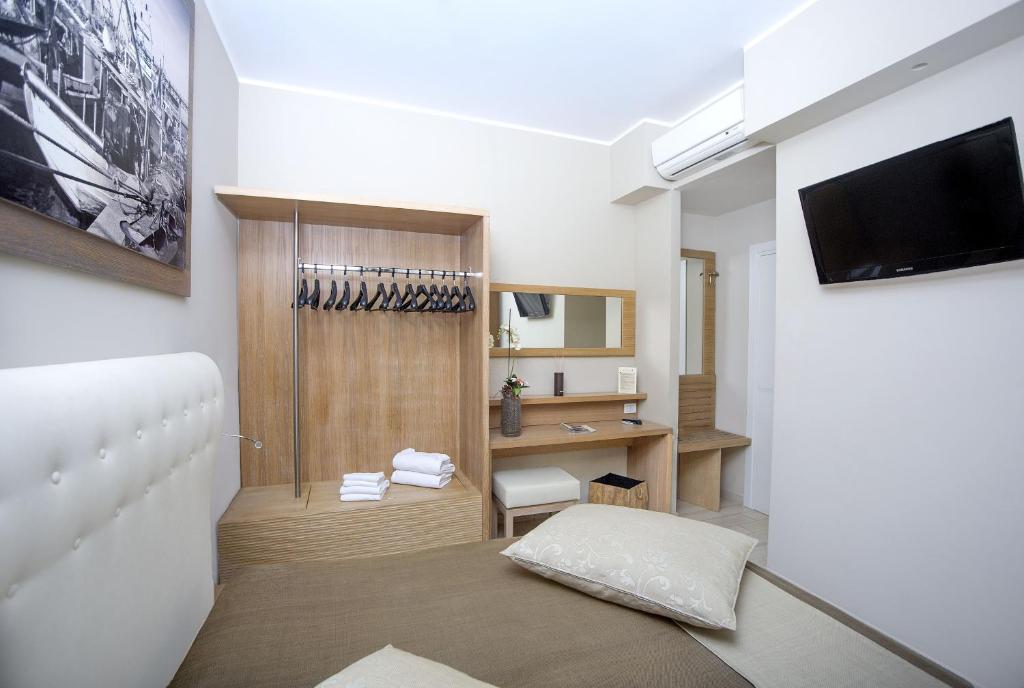 a room with a bed and a desk and a television at Hotel C'era Una Volta in Castiglione della Pescaia