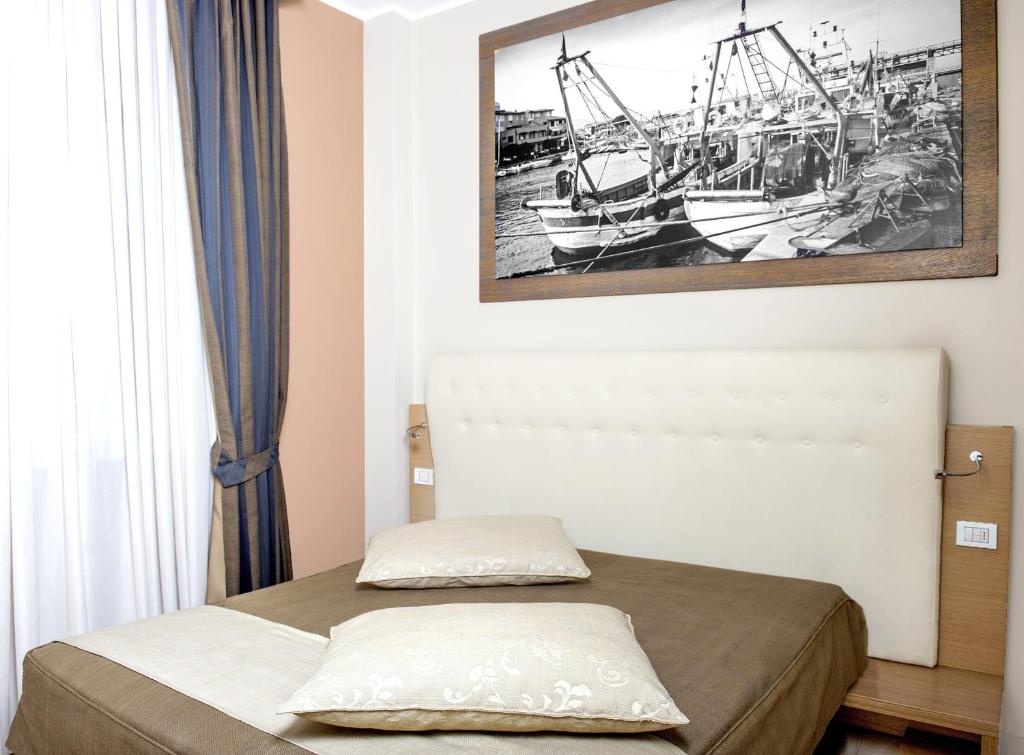 a bedroom with a bed and a picture of boats at Hotel C'era Una Volta in Castiglione della Pescaia