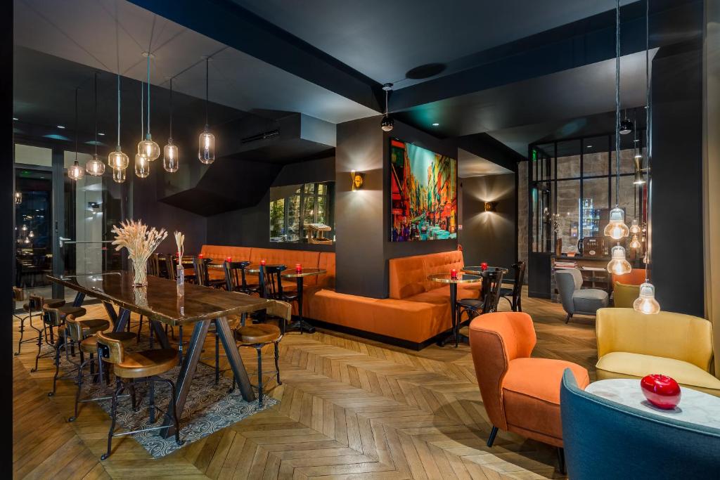 une salle à manger avec des chaises orange et une table dans l'établissement Hotel Scarlett, à Paris