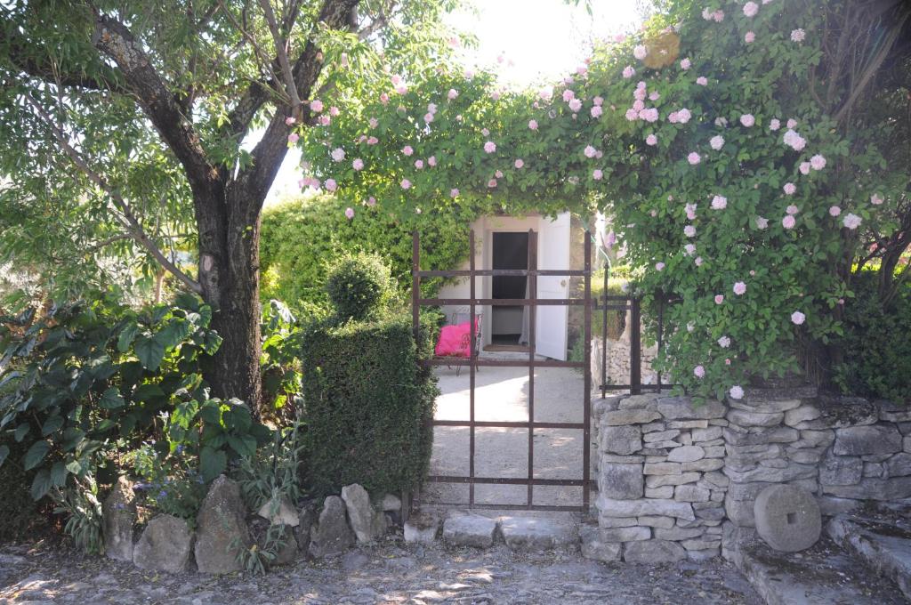 ein Tor mit rosa Blumen und einem Baum in der Unterkunft PROVENCEguesthouse L'Agaçon in Forcalquier