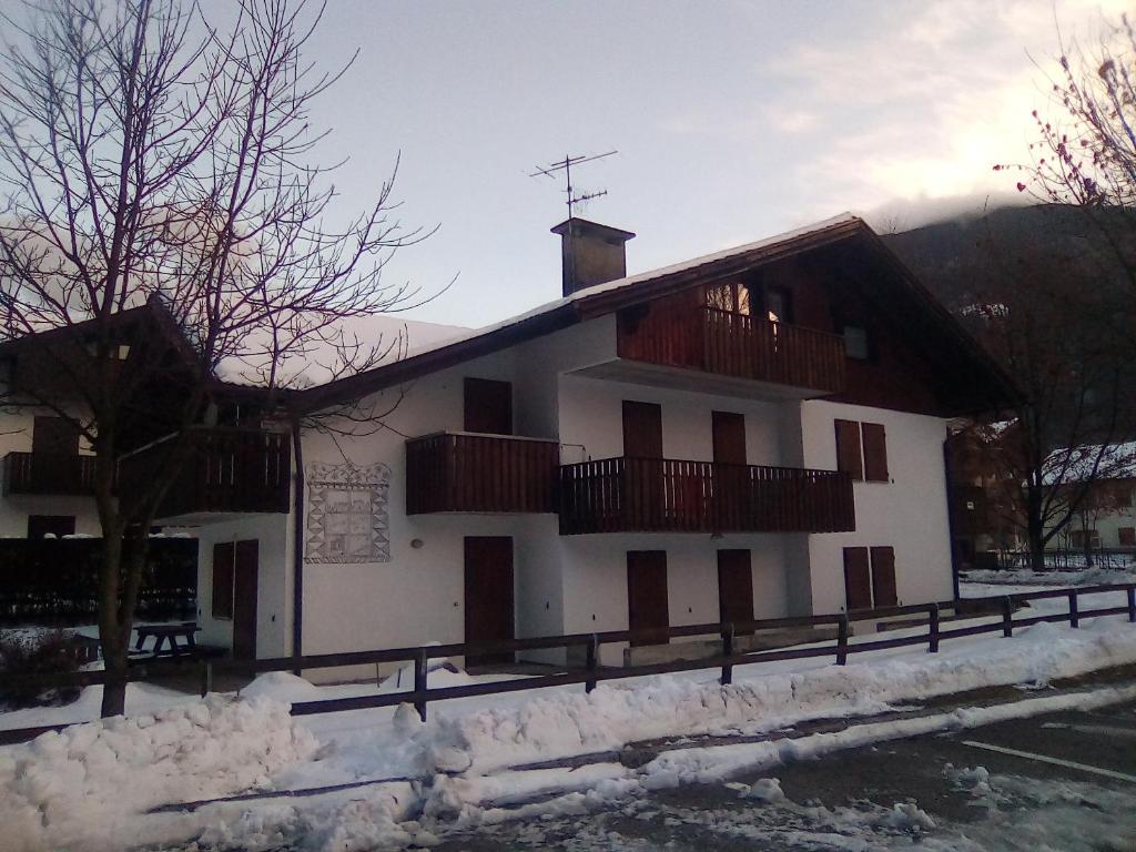 ピンツォーロにあるAppartamento Seppi Stile Trentinoのポーチとバルコニー付きの白い大きな建物