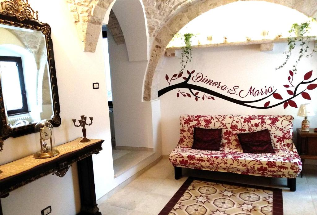 a living room with a couch and a mirror at Dimora Santa Maria in Putignano