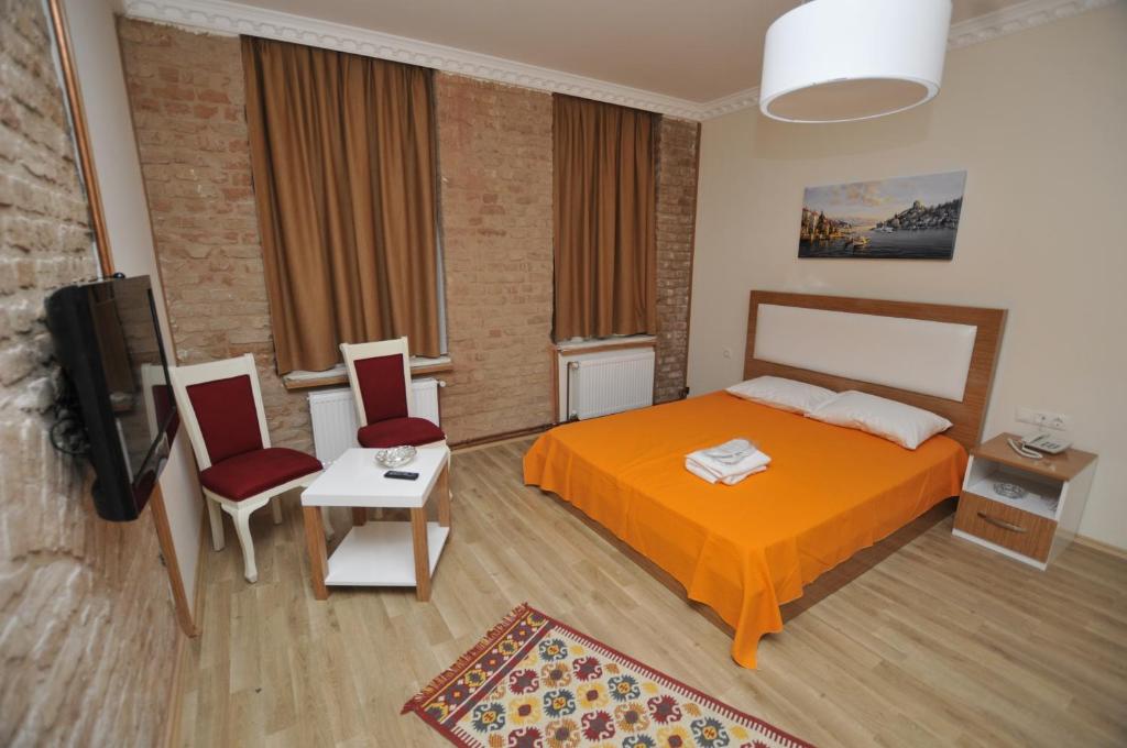 a bedroom with a bed and two chairs and a tv at Apartof in Istanbul