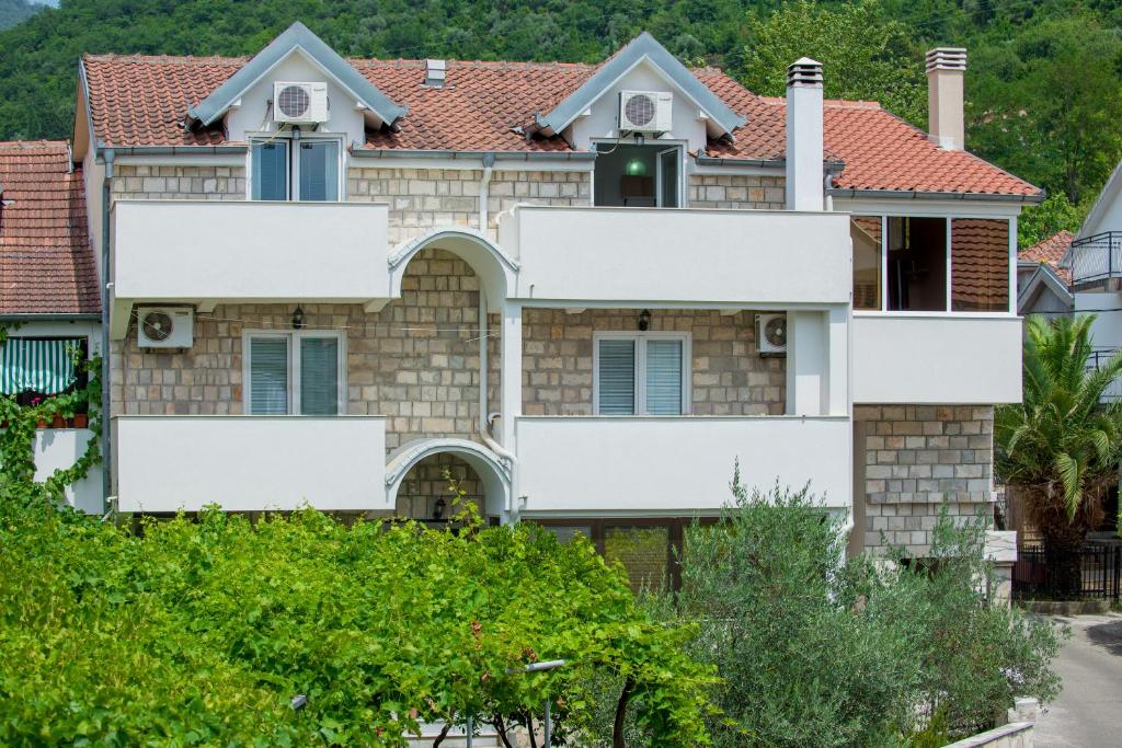 una casa con techo rojo en Apartmani Krgušić en Tivat